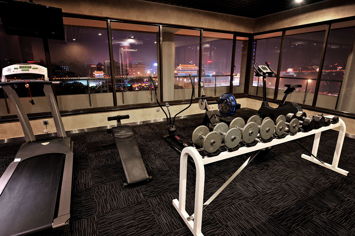 健身中心提供有氧健身器械，包括跑步機和舉重訓練設備